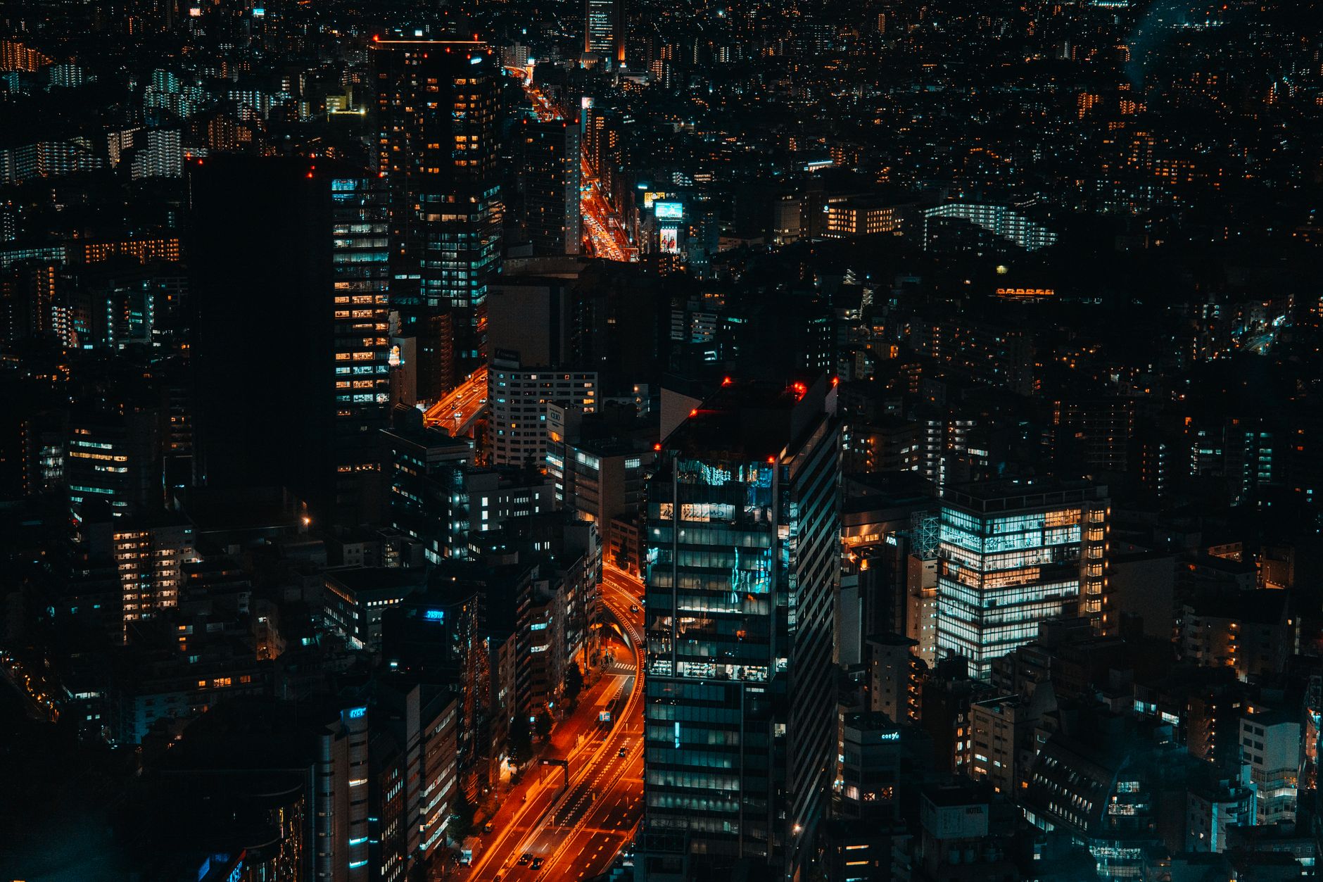 Skyline nocturno de una ciudad con luces de neón, la estética futurista del Área 11 en Code Geass