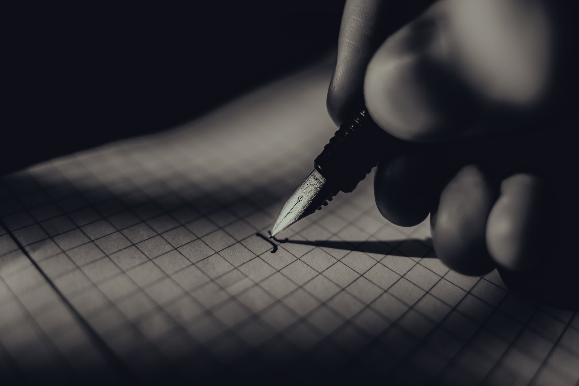 Cuaderno negro y pluma sobre superficie oscura, similar al Death Note