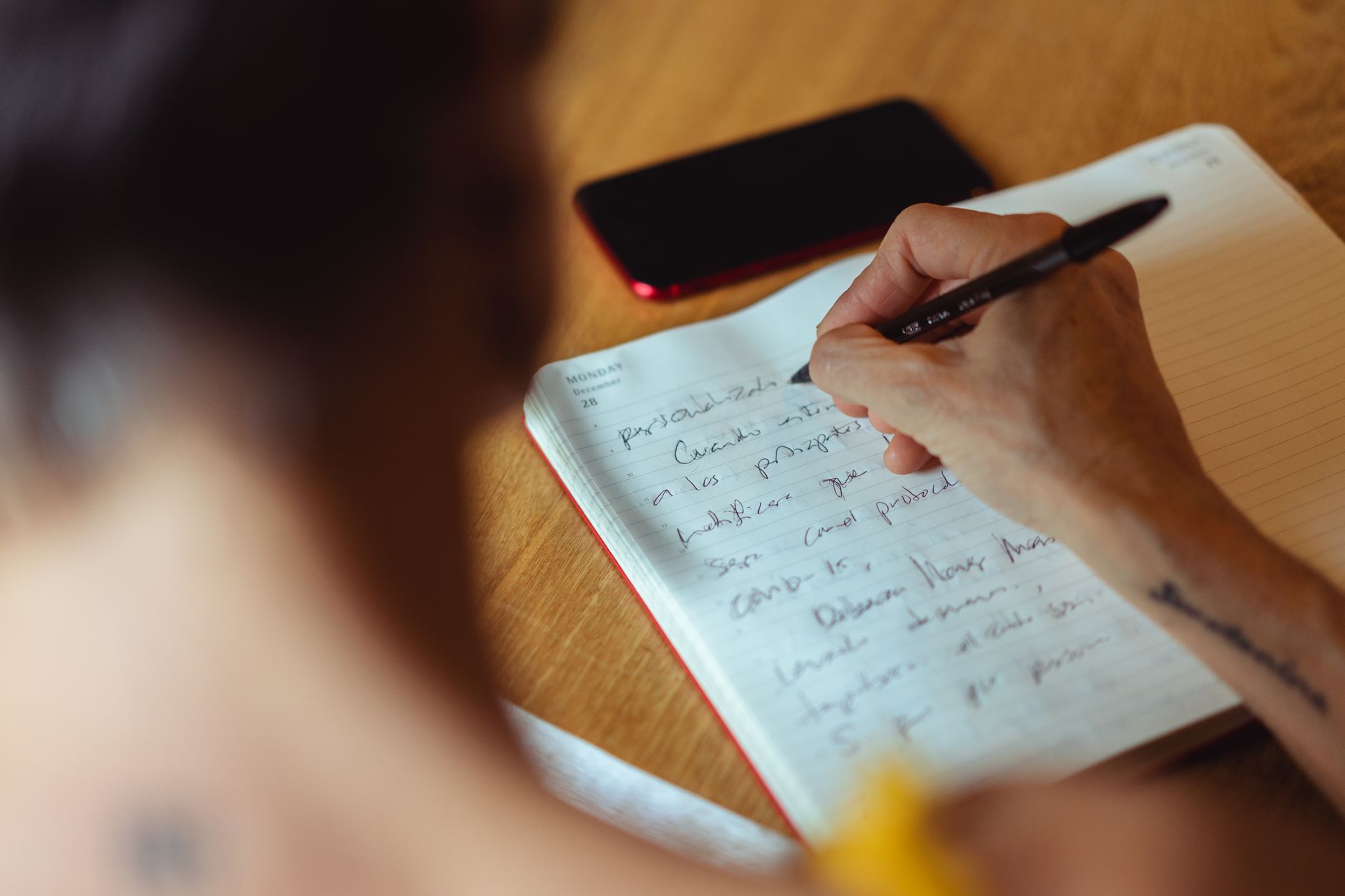 Person writing at a desk, the Hajime News editorial process