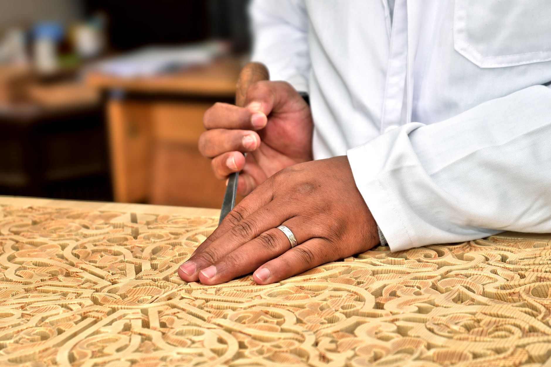 Manos tallando madera de forma artesanal, técnica cercana a la elaboración de utensilios tradicionales ainu que aparece en Golden Kamuy