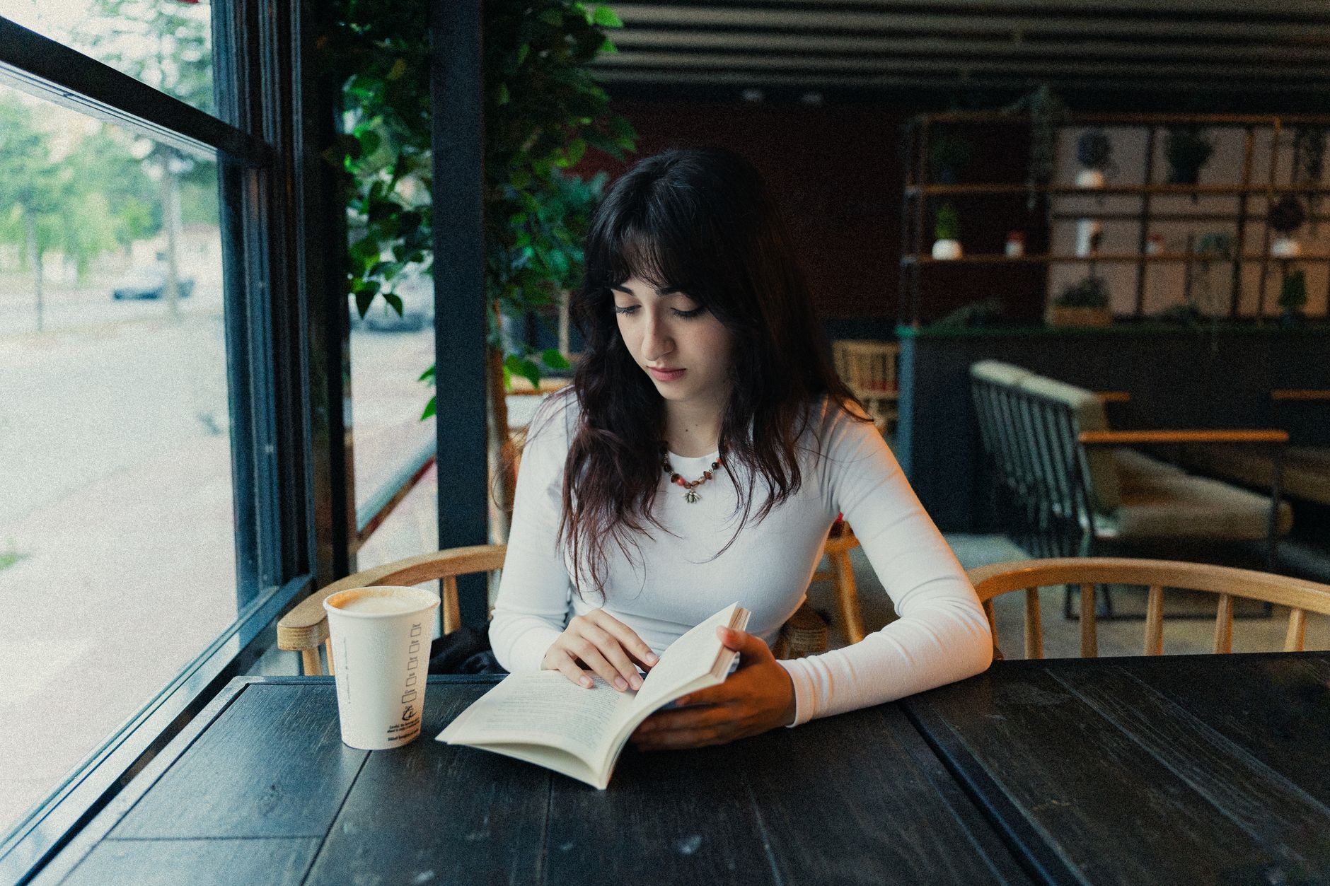 Persona leyendo tranquilamente en una cafetería, similar al público adulto de las obras seinen y josei