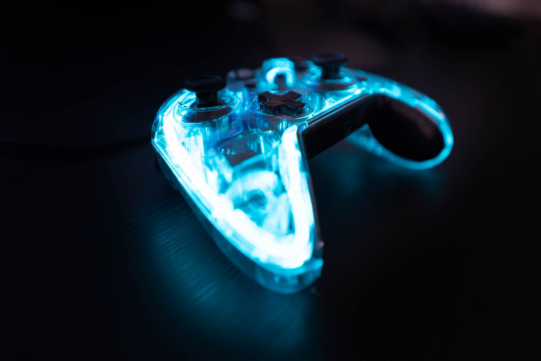 Mando de videojuego iluminado con luces de neón en la oscuridad, referencia a la estética de interfaz tipo RPG del Sistema de Solo Leveling